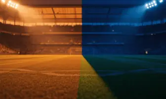 Floodlit empty football stadium pitch at golden hour with dramatic shadow patterns and blue-gold atmospheric lighting.