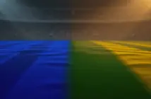 Empty floodlit stadium pitch at golden-hour kick-off with blue and green-yellow shadow patterns, no players