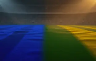 Empty floodlit stadium pitch at golden-hour kick-off with blue and green-yellow shadow patterns, no players