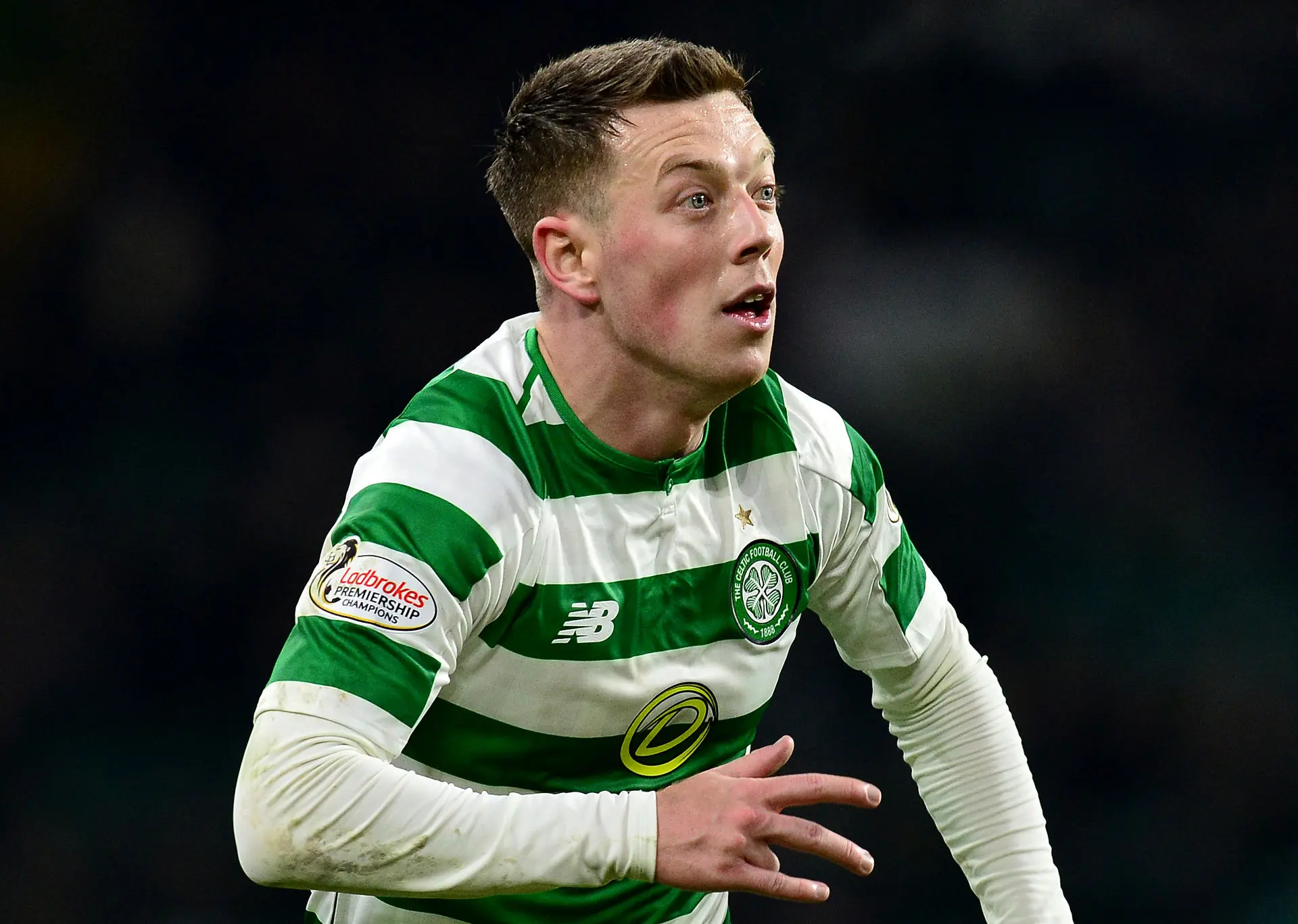 Callum McGregor in a Celtic jersey during a match, displaying intense focus.