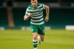 Football striker in Celtic green and white hooped jersey sprinting on pitch