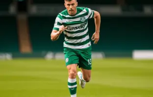 Football striker in Celtic green and white hooped jersey sprinting on pitch