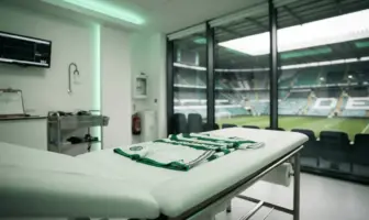 Modern football medical room with green kit awaiting player examination before transfer signing