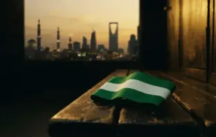 Celtic captain armband on locker bench with Saudi cityscape in background