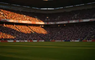 Floodlit football stadium at golden hour with packed stands, dramatic shadows, and cinematic lighting during quarter-final match atmosphere.