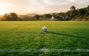 Football training pitch in Portugal at golden hour with pristine green grass and white lines