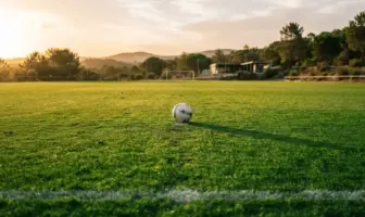 Football training pitch in Portugal at golden hour with pristine green grass and white lines