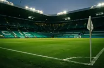 Empty football stadium with Celtic green lighting at dusk before Champions League play-off match