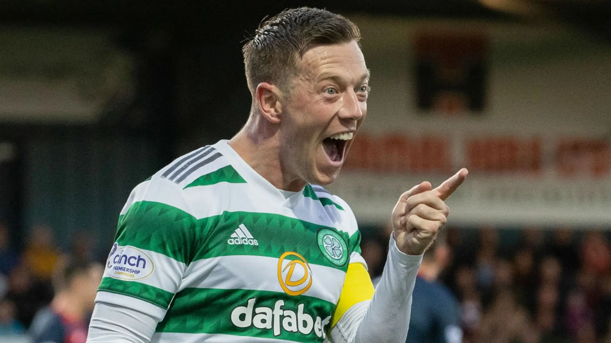 Callum McGregor celebrating in a Celtic FC home kit with a captain's armband