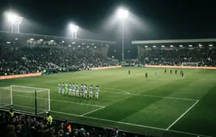 Celtic players celebrate a dominant Champions League play-off advantage under stadium lights