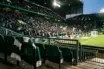 Green-and-white scarf in a floodlit stadium representing Celtic’s Champions League opportunity and potential revenue.