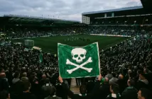 Celtic supporters display a green banner at Celtic Park while backing the team and protesting the board