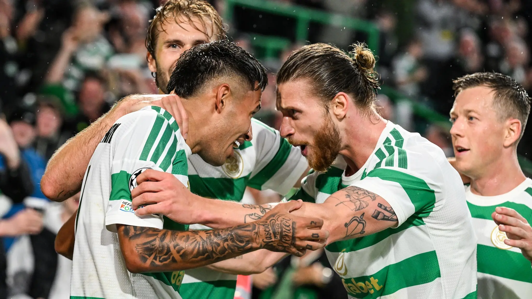 Celtic FC players celebrating a goal in their green and white hooped kits during a Champions League match