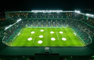 Floodlit football stadium with green-and-white atmosphere representing Celtic’s Europa League league-phase draw