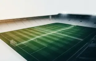 Green-and-white football pitch under stadium lights symbolising Celtic’s rescheduled league fixtures and Europa League schedule.