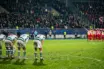 Dejected Celtic-inspired players react after a dramatic European football collapse in a floodlit stadium