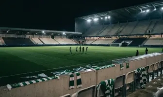 Empty stadium after Celtic’s Champions League exit, with green-and-white supporter colours under night floodlights