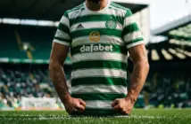Celtic player in green and white hooped jersey standing ready at Celtic Park stadium