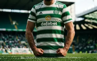 Celtic player in green and white hooped jersey standing ready at Celtic Park stadium