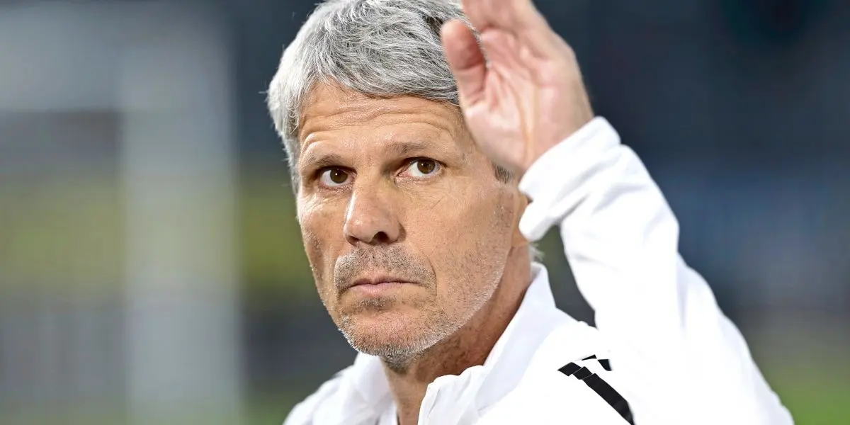 Close-up portrait of Didi Kühbauer wearing a white athletic jacket with black stripes