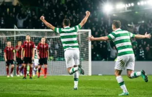 Celtic-style striker celebrates a decisive volley in a floodlit European play-off match