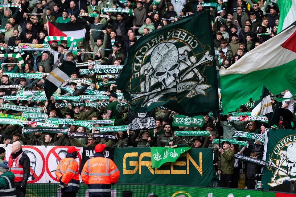 Green Brigade supporters at Celtic Park waving a large green skull and crossbones banner