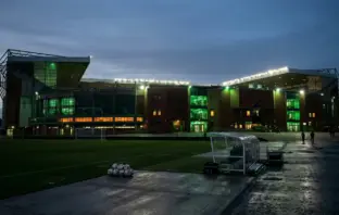 Celtic Park at dusk representing the debate between European ambition and financial caution after the LASK exit