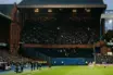 Historic football stadium showing a tiny away section against a full home stand during a tense derby