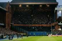 Historic football stadium showing a tiny away section against a full home stand during a tense derby
