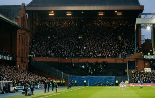 Historic football stadium showing a tiny away section against a full home stand during a tense derby