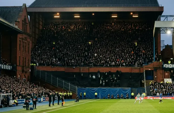 Historic football stadium showing a tiny away section against a full home stand during a tense derby