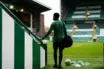Young midfielder in green training kit arriving at a football stadium for a new club chapter