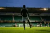 Celtic-inspired midfielder silhouette training under stadium lights ahead of a derby quarter-final