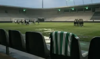 Empty football stadium bench with a green-and-white shirt after a defeat