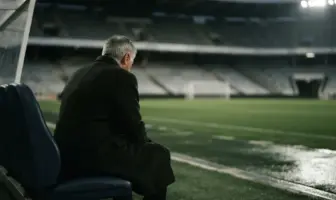 Older football manager silhouette reflecting alone in a stadium after a difficult week