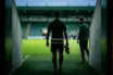 Young footballer walking toward a green-lit pitch as he begins a new chapter after leaving Celtic