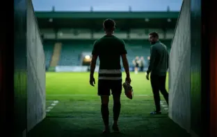Young footballer walking toward a green-lit pitch as he begins a new chapter after leaving Celtic