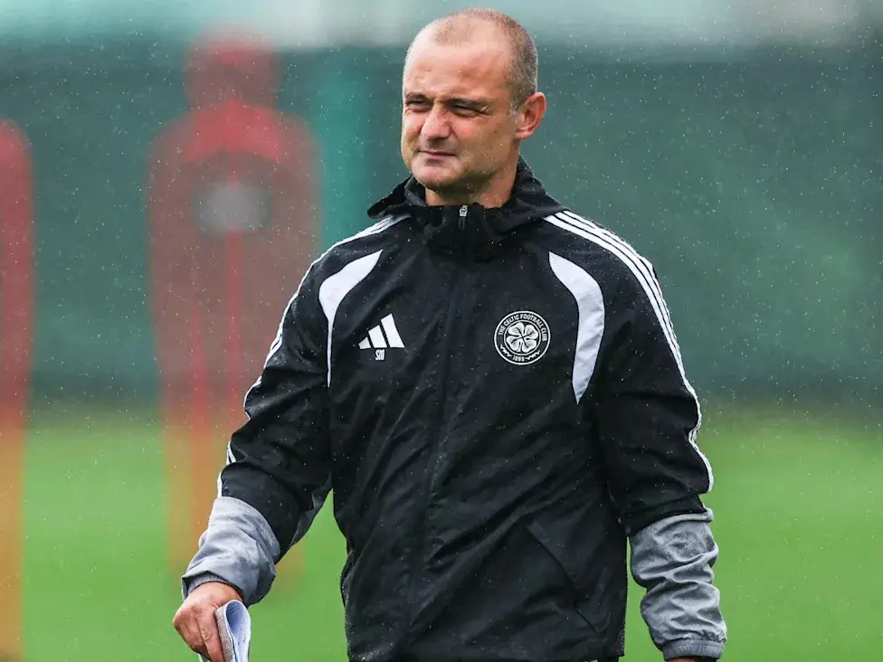 Shaun Maloney wearing a black Celtic FC training jacket on a rainy football pitch