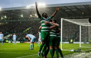 Celtic-inspired players celebrate a dramatic comeback victory in a rain-lit stadium